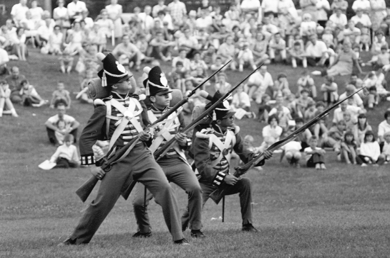 Three guardsmen perform a musket drill for onlookers