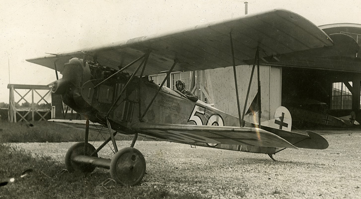 William Barker standing beside a biplane aircraft